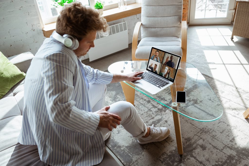 Man on a teams meeting, working from his sofa at home.